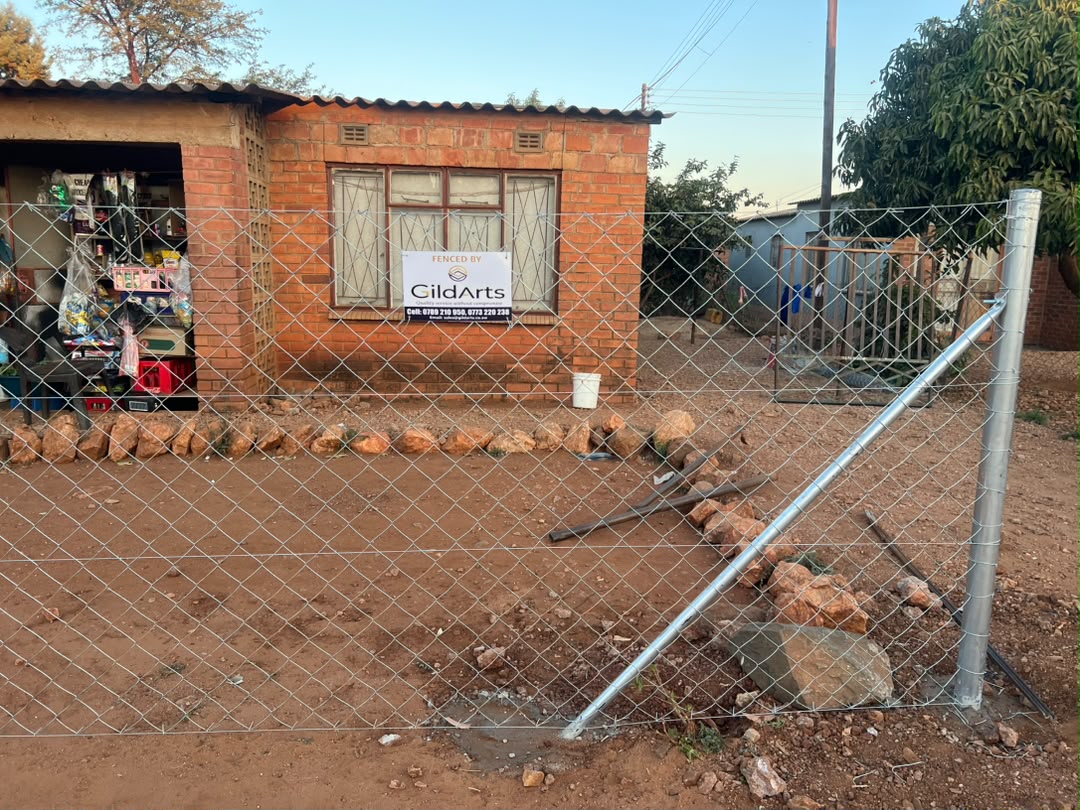 Chain-link fence protecting a home and shop front installed by GildArts