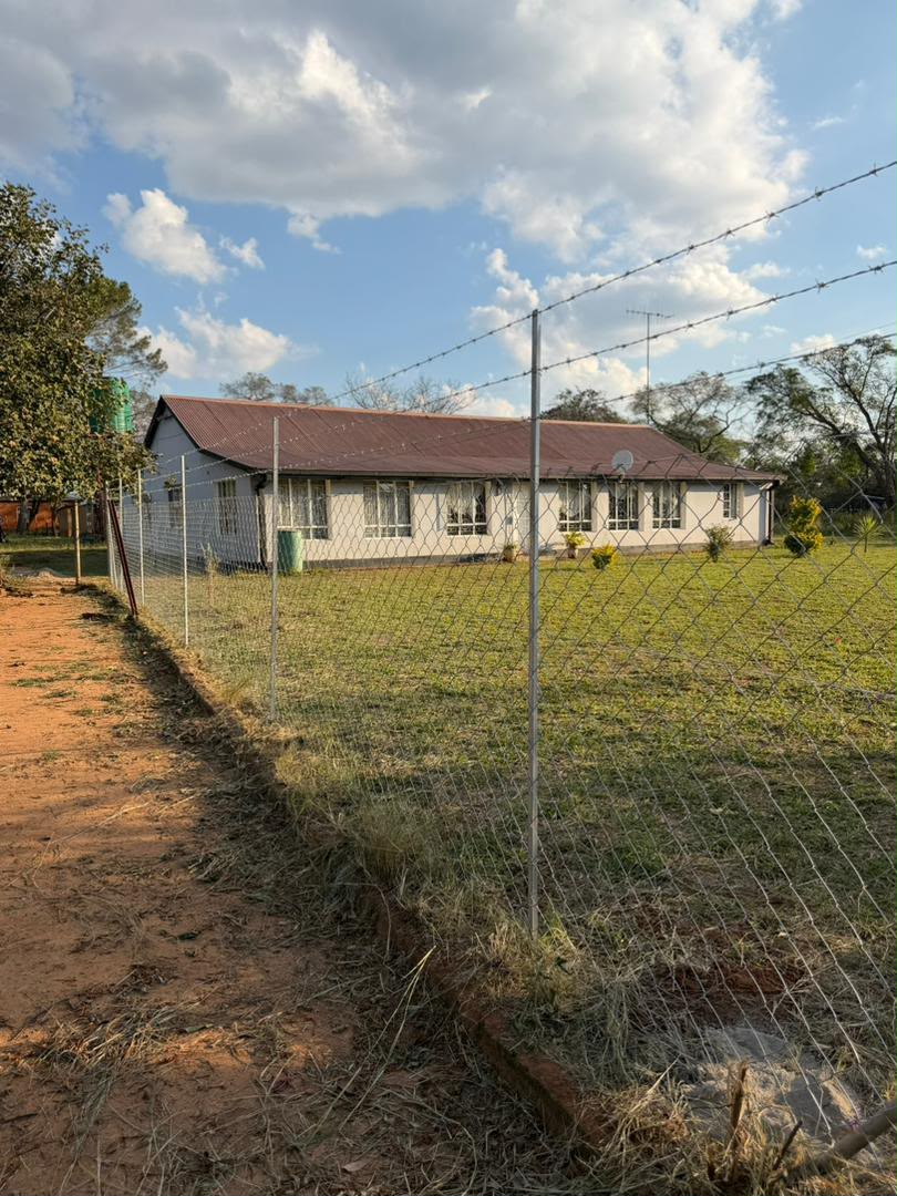 Farmhouse boundary diamond mesh fence with barbed wire installed by GildArts